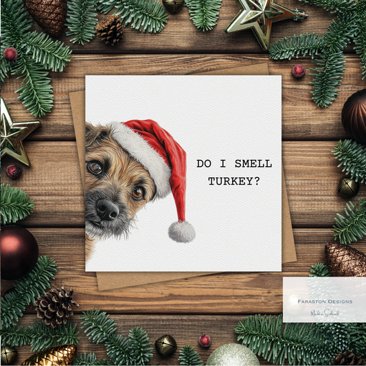 Card with a dog wearing a Santa hat and text 'Do I smell turkey?' surrounded by Christmas decorations on a wooden surface.
